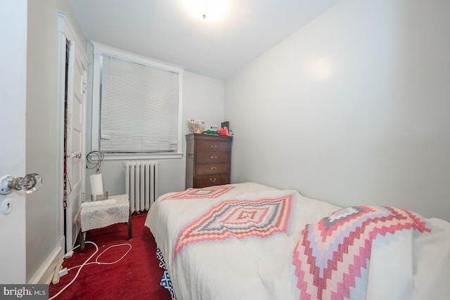 bedroom with dark colored carpet, radiator heating unit, and vaulted ceiling