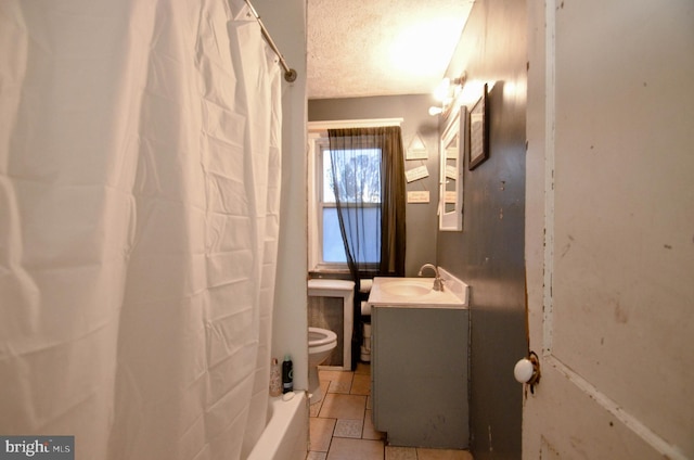 bathroom featuring tile patterned flooring, a textured ceiling, vanity, and toilet