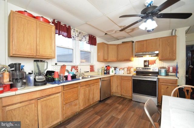 kitchen with appliances with stainless steel finishes, dark hardwood / wood-style flooring, a drop ceiling, ceiling fan, and sink