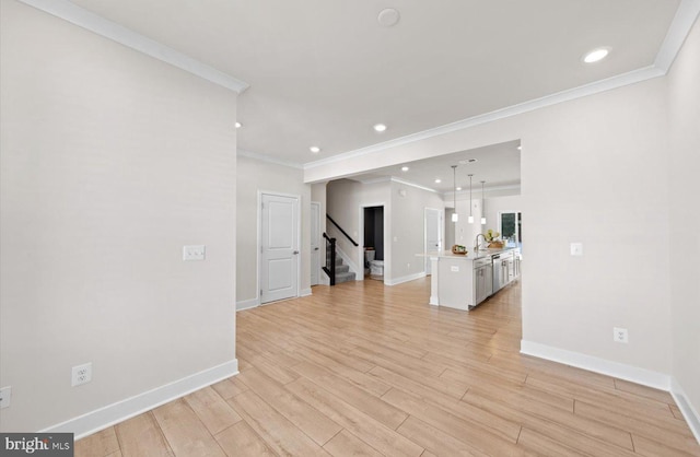 unfurnished room with light hardwood / wood-style floors, crown molding, and sink