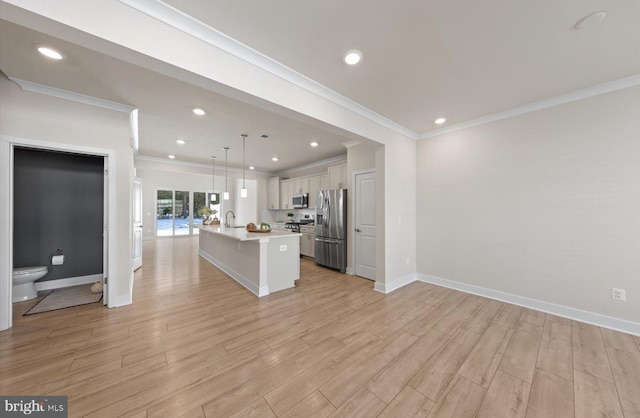 kitchen featuring a kitchen island with sink, stainless steel appliances, light wood-type flooring, hanging light fixtures, and white cabinets