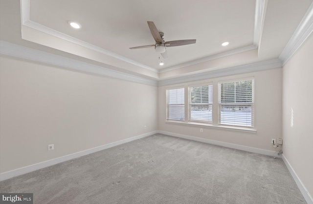 spare room with ceiling fan, crown molding, light carpet, and a tray ceiling