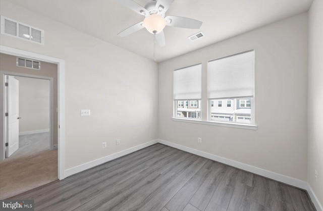 empty room with ceiling fan and light hardwood / wood-style flooring