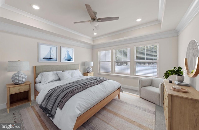 bedroom featuring a raised ceiling, light carpet, ceiling fan, and ornamental molding