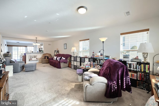 carpeted living room featuring a chandelier