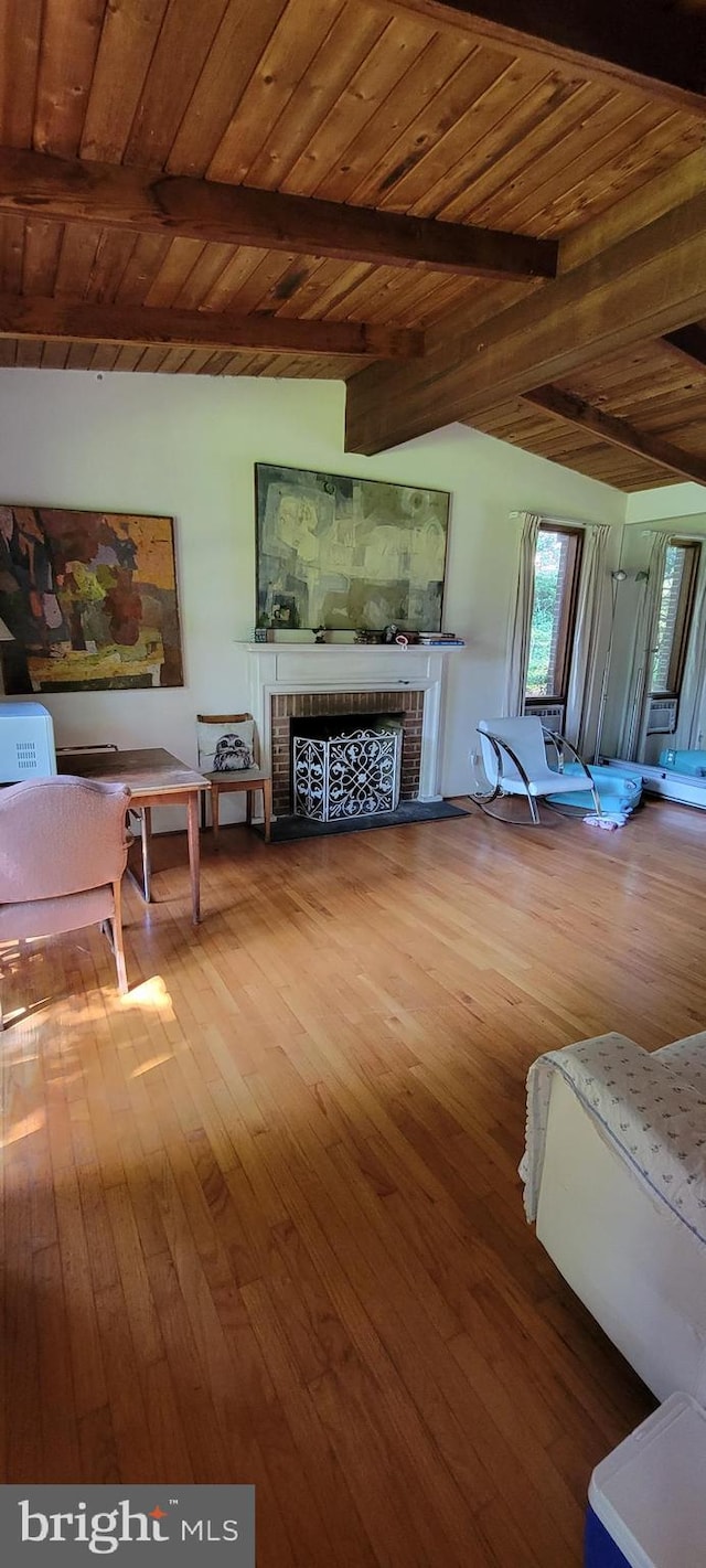 living room with a fireplace, lofted ceiling with beams, wood ceiling, and hardwood / wood-style floors