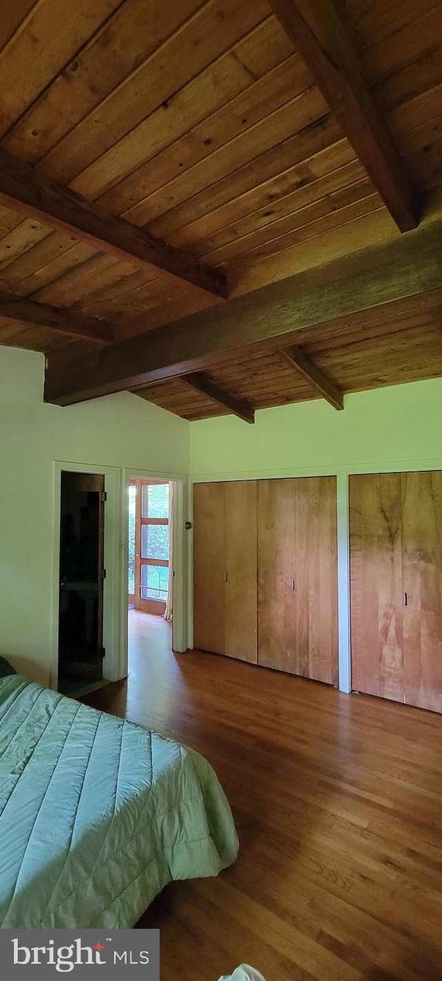 unfurnished bedroom featuring hardwood / wood-style flooring, wooden ceiling, and beamed ceiling