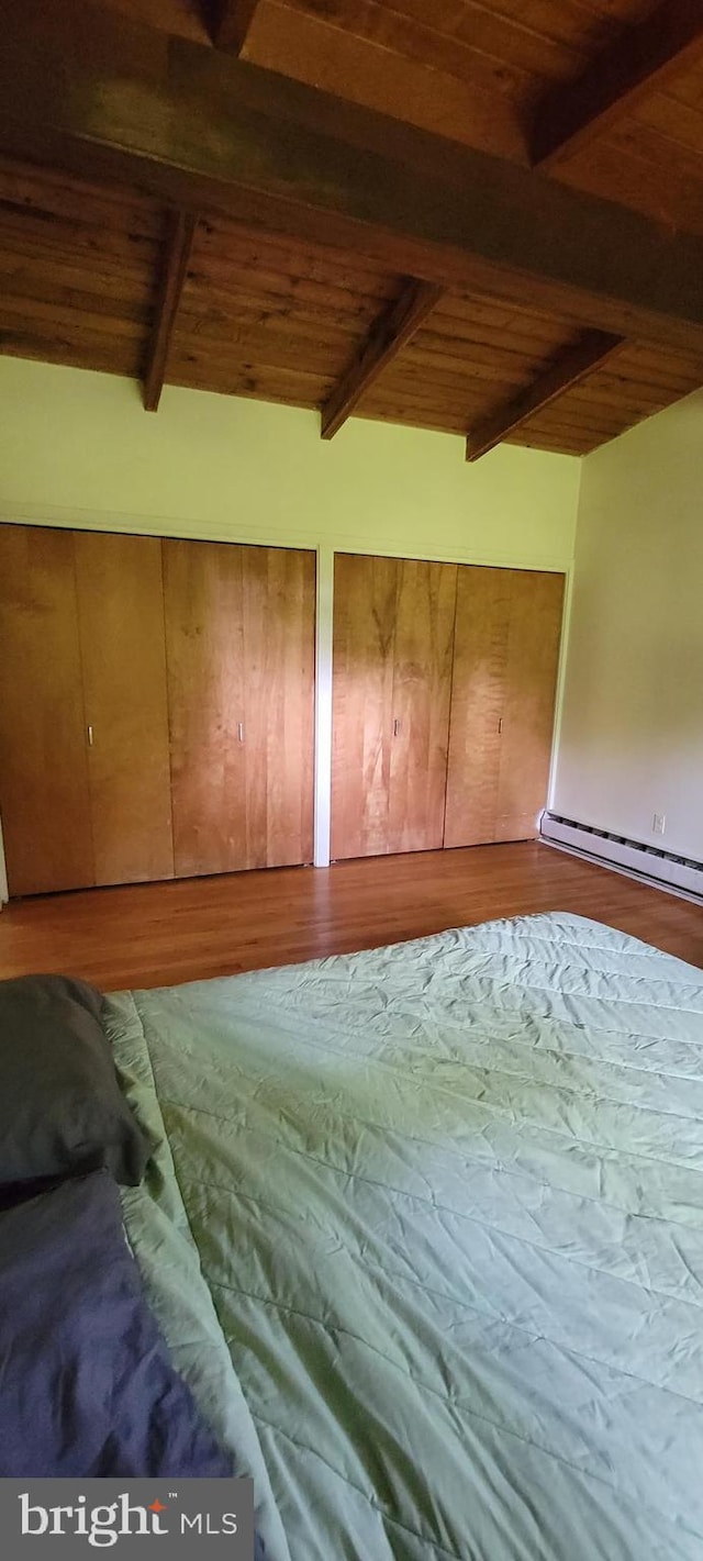 additional living space featuring beamed ceiling, a baseboard radiator, hardwood / wood-style flooring, and wood ceiling