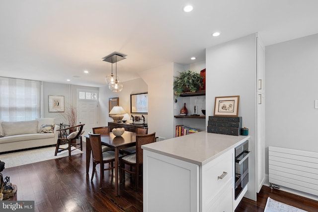 kitchen with pendant lighting, sink, white cabinetry, and dark wood-type flooring