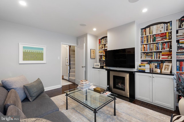 living room featuring dark hardwood / wood-style flooring and built in features