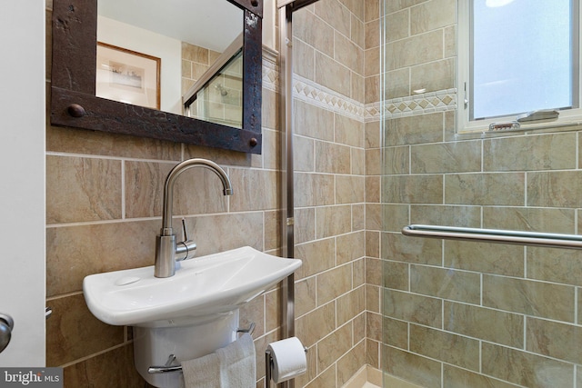 bathroom featuring backsplash, sink, and tiled shower