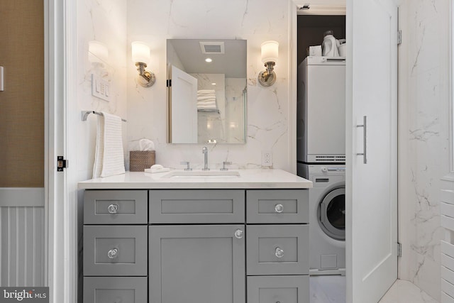 bathroom with vanity and stacked washer / dryer