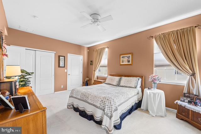 carpeted bedroom with a closet and ceiling fan