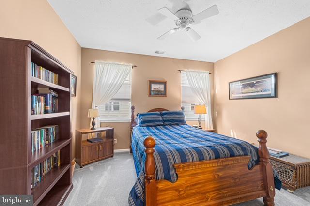 bedroom with ceiling fan and light colored carpet