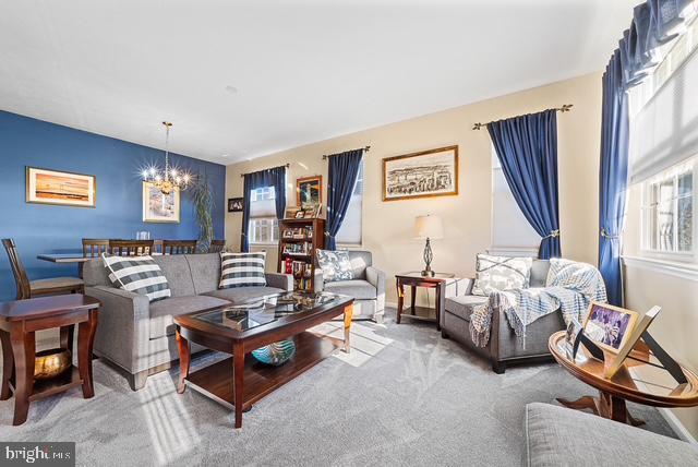 living room with carpet floors and a chandelier