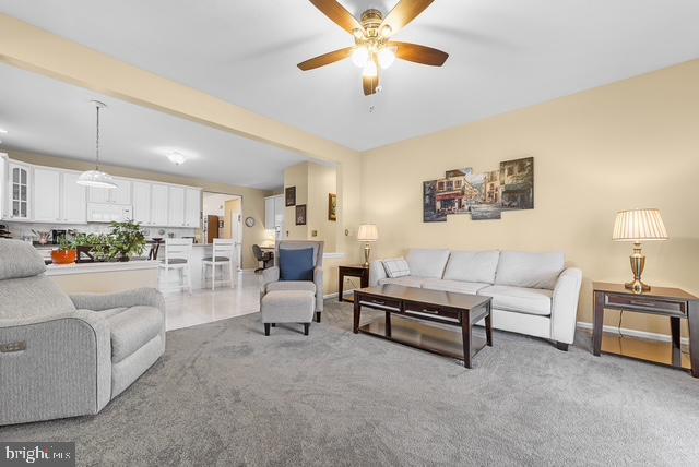 carpeted living room featuring ceiling fan