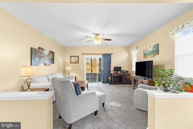 living room featuring a wealth of natural light, ceiling fan, and light colored carpet