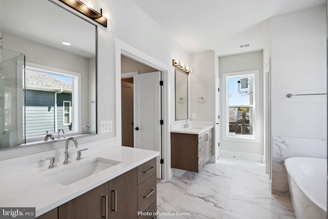 bathroom featuring a bathing tub, vanity, and tile walls