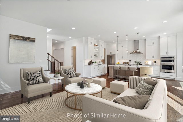 living room with hardwood / wood-style flooring and sink