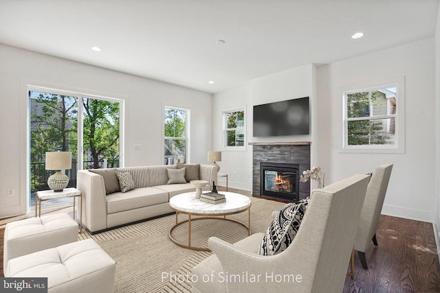 living room featuring a tile fireplace and hardwood / wood-style flooring