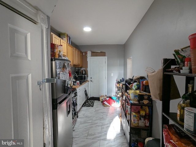 kitchen with stainless steel fridge and light brown cabinets