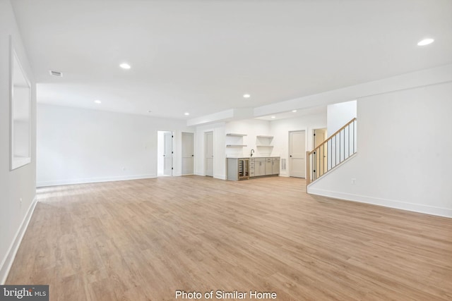 unfurnished living room featuring light hardwood / wood-style floors and sink