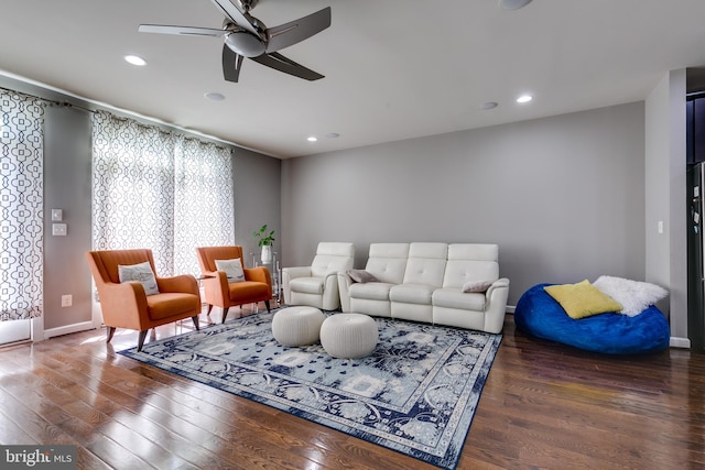 living room featuring ceiling fan and dark hardwood / wood-style floors