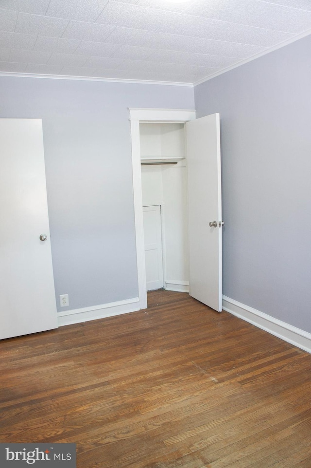 unfurnished bedroom featuring dark hardwood / wood-style floors and a closet