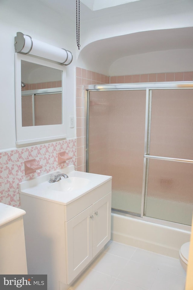 full bathroom with tile patterned flooring, vanity, toilet, and shower / bath combination with glass door