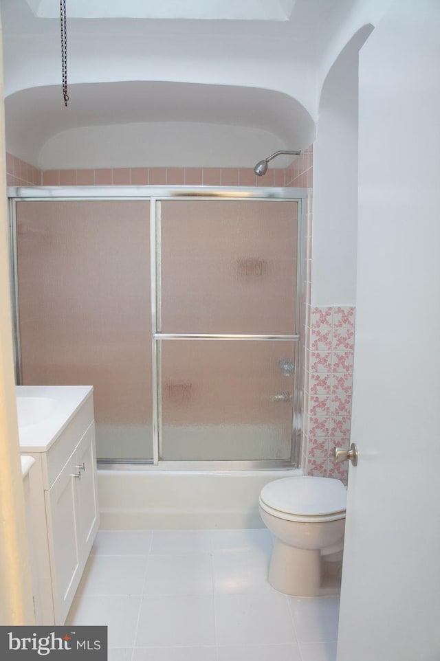 full bathroom featuring shower / bath combination with glass door, tile patterned floors, vanity, and toilet