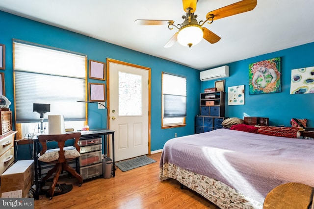 bedroom featuring a wall mounted air conditioner, ceiling fan, and light hardwood / wood-style floors