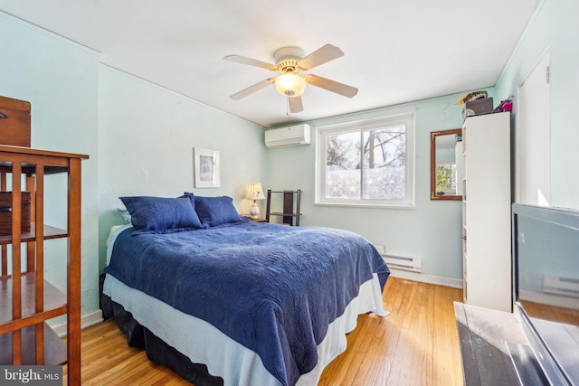 bedroom with ceiling fan, baseboard heating, light hardwood / wood-style flooring, and a wall mounted AC