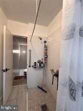 bathroom with walk in shower and tile walls