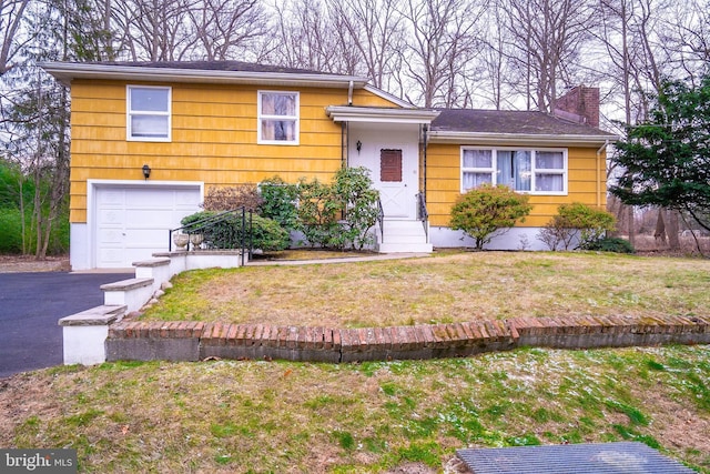 split level home with a front yard and a garage