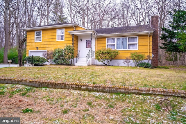 tri-level home with a garage and a front lawn