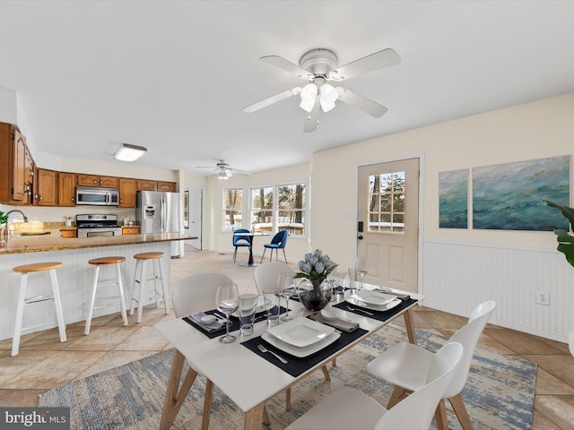 tiled dining area featuring ceiling fan and sink