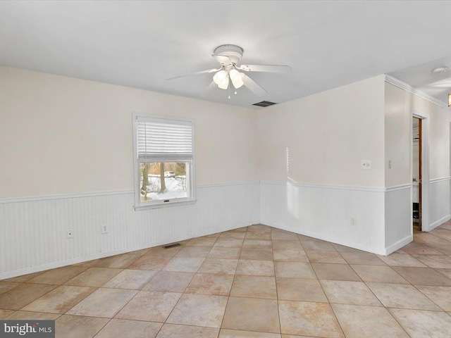 tiled spare room featuring ceiling fan