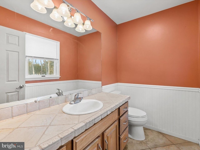 bathroom with toilet, vanity, and tile patterned floors