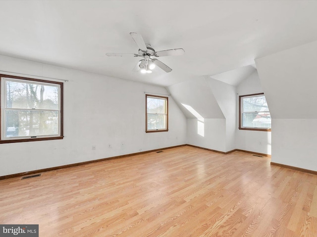 additional living space with ceiling fan, light hardwood / wood-style floors, and vaulted ceiling