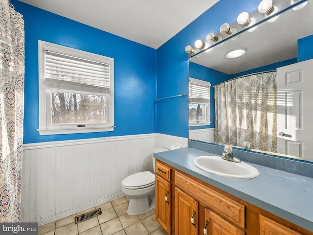 bathroom with tile patterned floors, vanity, toilet, and wooden walls