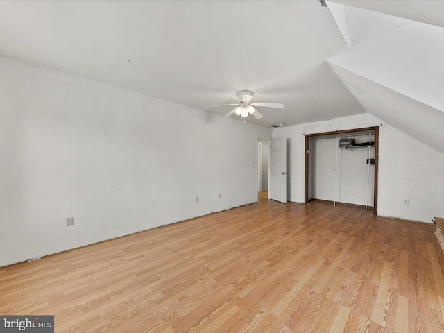 additional living space with light hardwood / wood-style flooring, vaulted ceiling, and ceiling fan