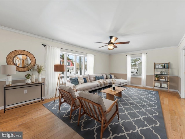 living room featuring light hardwood / wood-style flooring, a wealth of natural light, and crown molding