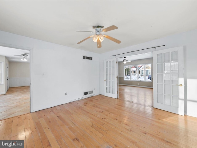 unfurnished room with french doors and light wood-type flooring