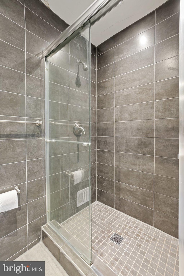 bathroom featuring a shower with shower door