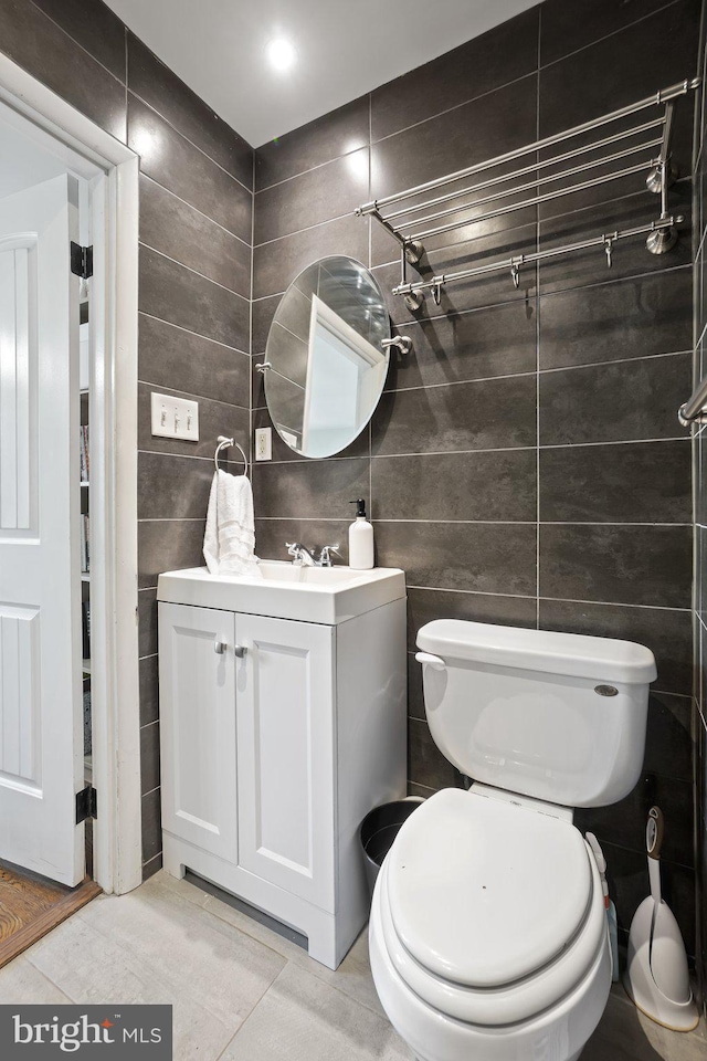 bathroom with toilet, vanity, and tile patterned floors