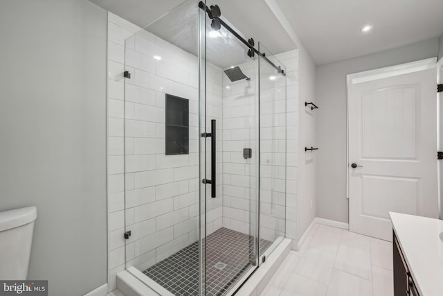 bathroom featuring tile patterned flooring, vanity, toilet, and walk in shower