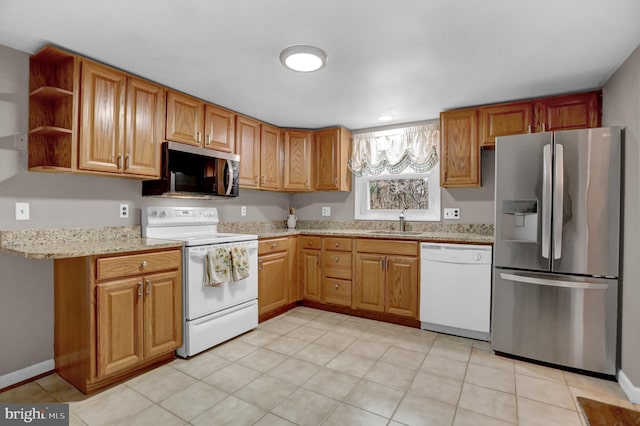 kitchen with light stone counters, sink, and stainless steel appliances