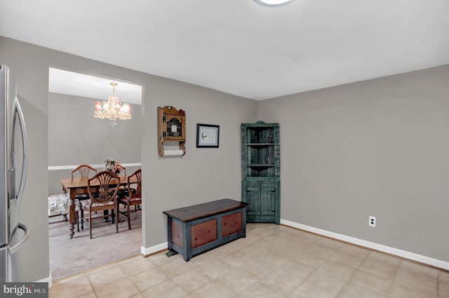 spare room featuring light colored carpet and a chandelier