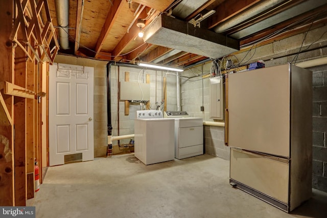 basement featuring fridge and washer and dryer