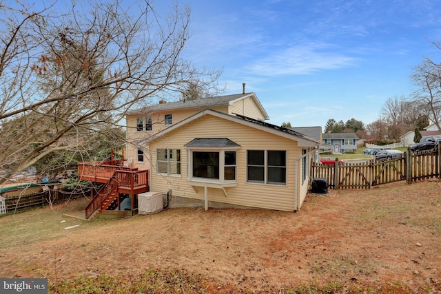 back of house featuring a deck and a lawn